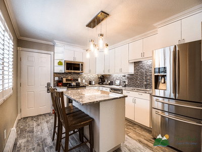 Modern full kitchen with island, white cabinets, and stainless steel appliances.